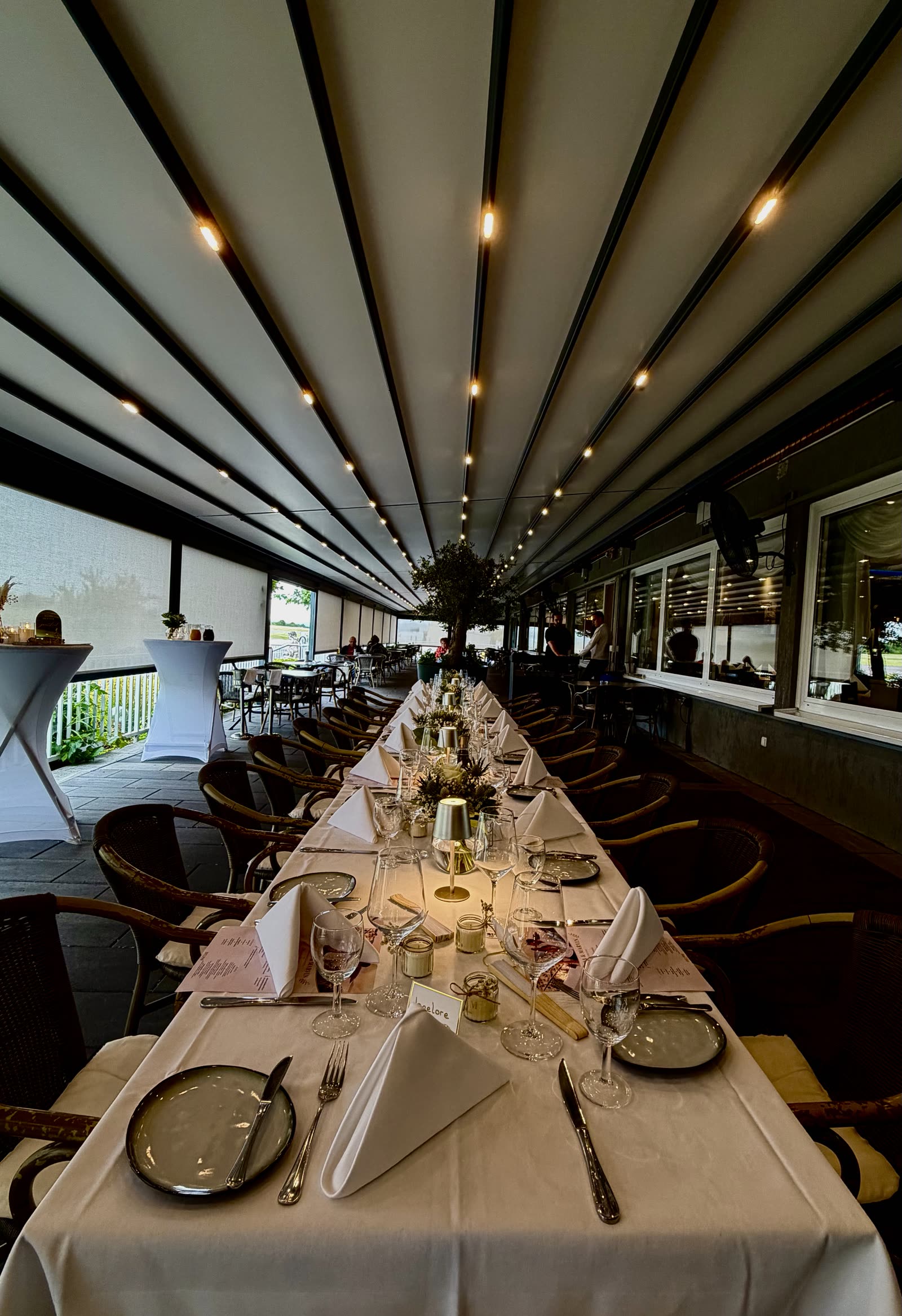 Lange festlich gedeckte Tafel auf der Terrasse